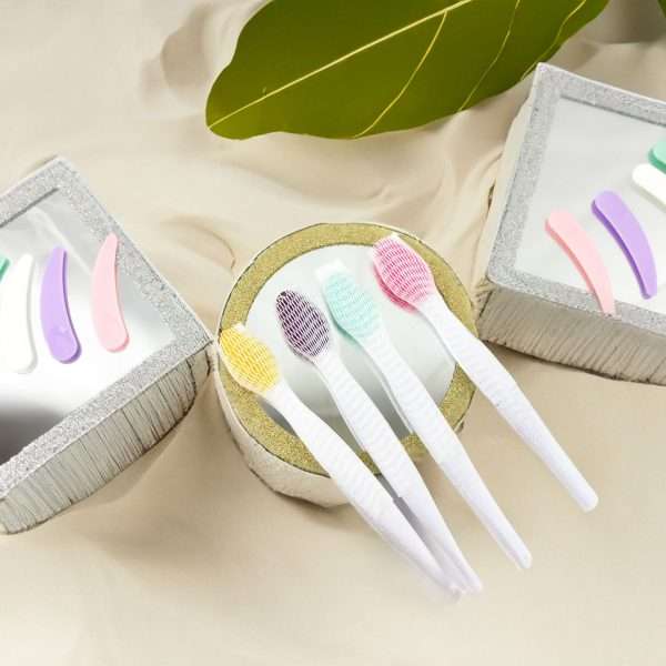 Set of small brushes with colorful bristles in a container on a beige surface.